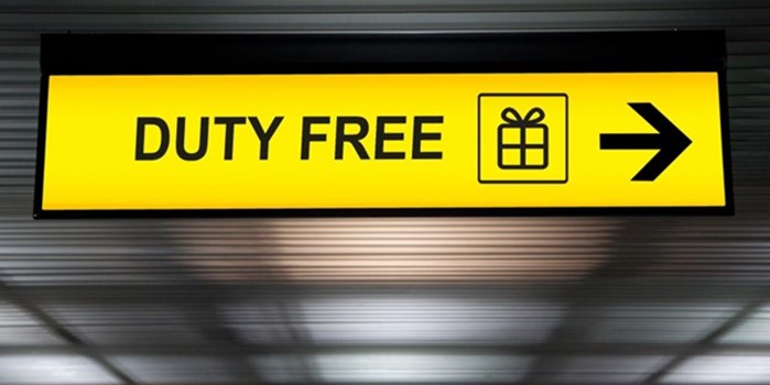 A yellow backlit sign with the words ‘duty free’ and an arrow pointing to the right